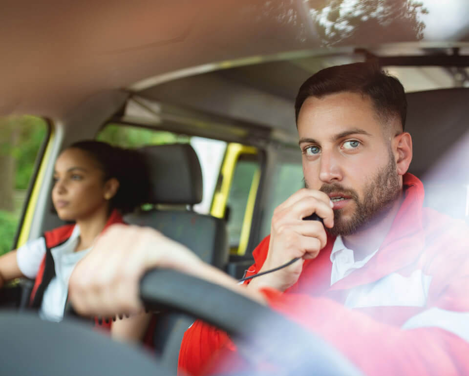 Caladis-Fuhrparkveraltung-mobil Mann am Steuer eines Krankenwagens spricht in Funkgerät
